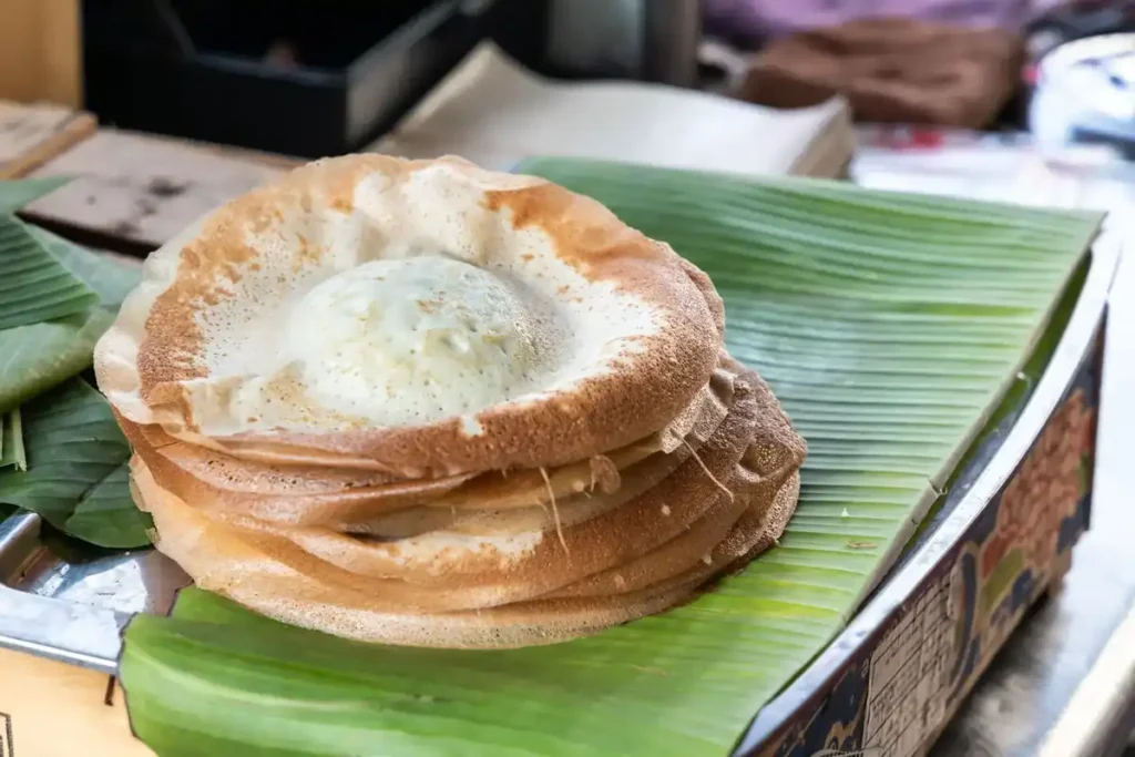 Penang Apom Manis adalah camilan manis khas Penang yang mirip pancake, terbuat dari tepung beras dan santan. Rasanya manis dengan tekstur lembut di bagian tengah dan renyah di tepinya.